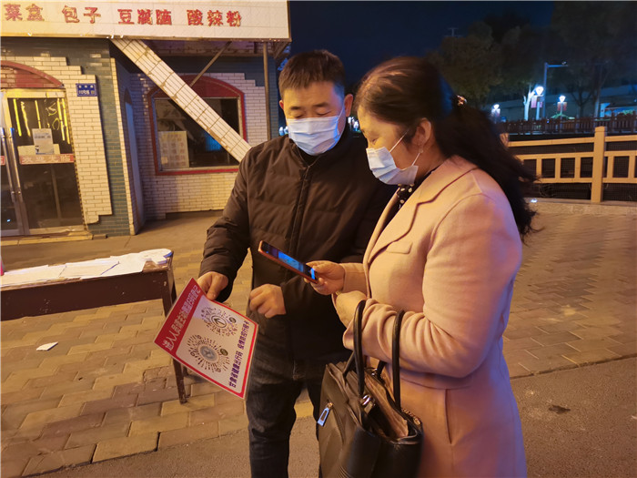 10月23日晚，张掖市纪委监委纪检监察干部在社区门口值守对小区出入居民进行扫码登记。_副本.jpg